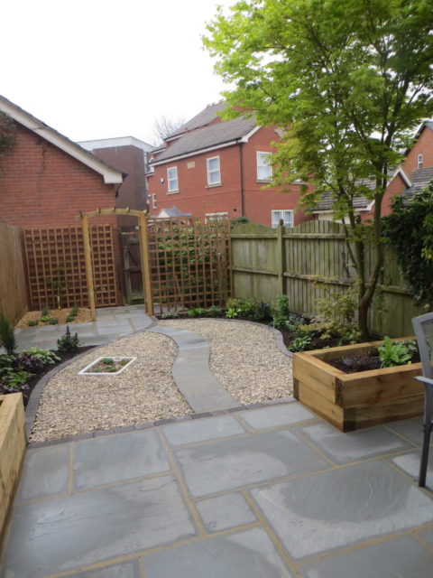 A small courtyard garden created around existing paving with lots of ...